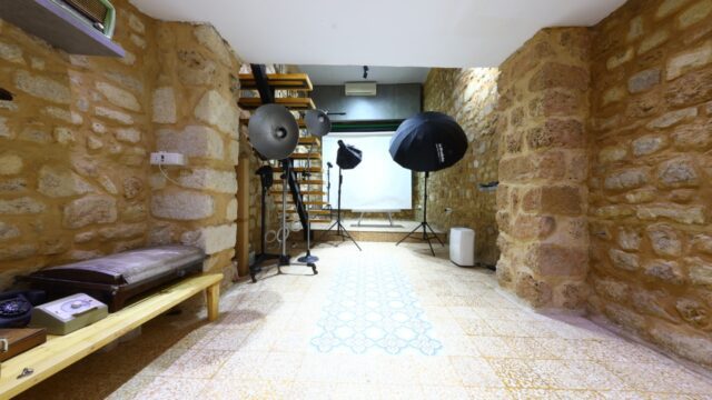 a room with a stone wall and a white backdrop