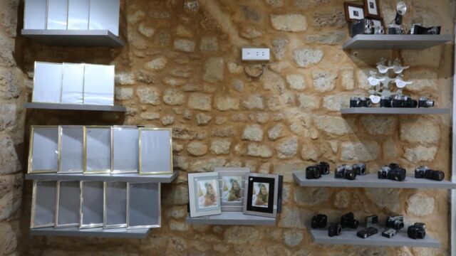 a wall with shelves and pictures on it