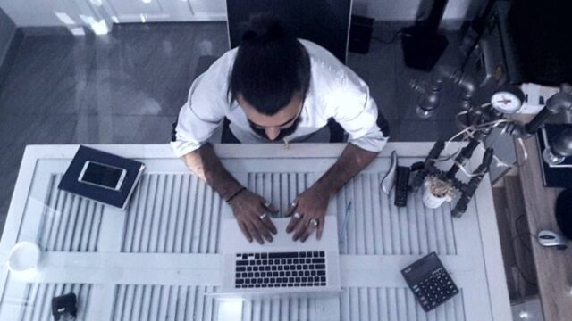 a man sitting at a desk using a laptop