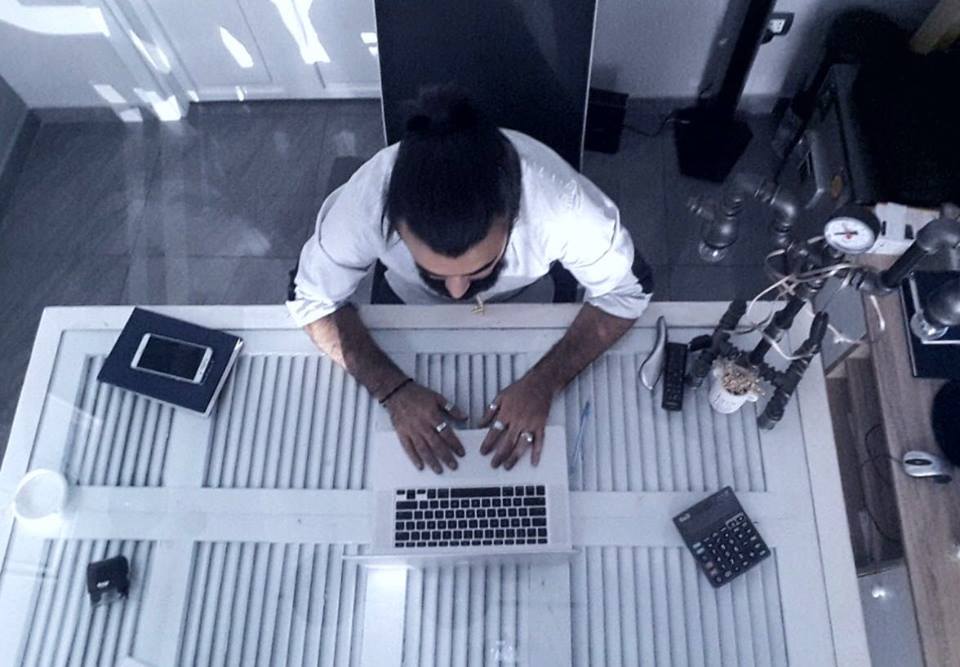 a man sitting at a desk using a laptop