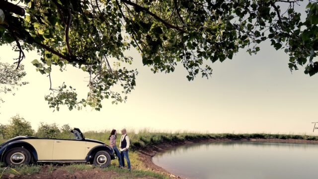 a man and woman standing next to a car