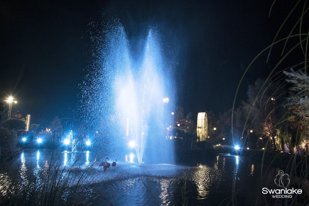 a water fountain with a light in the background