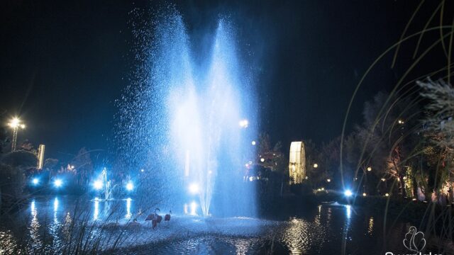 a water fountain with a light in the background