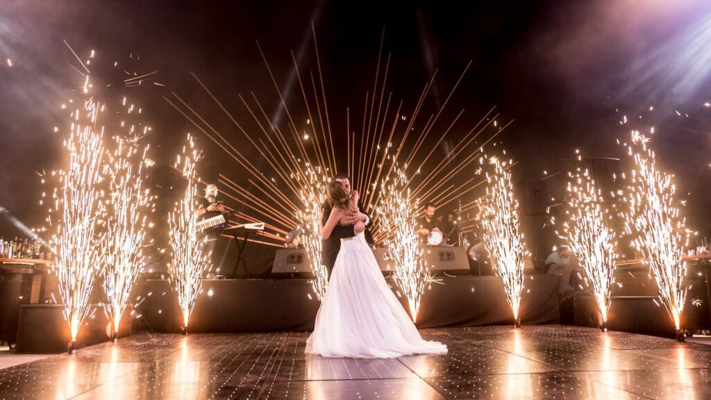 a man and woman dancing on a stage with fireworks