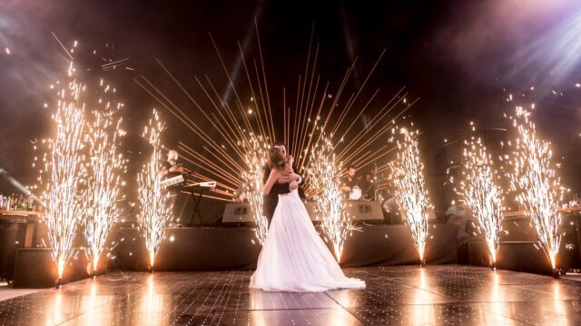 a man and woman dancing on a stage with fireworks