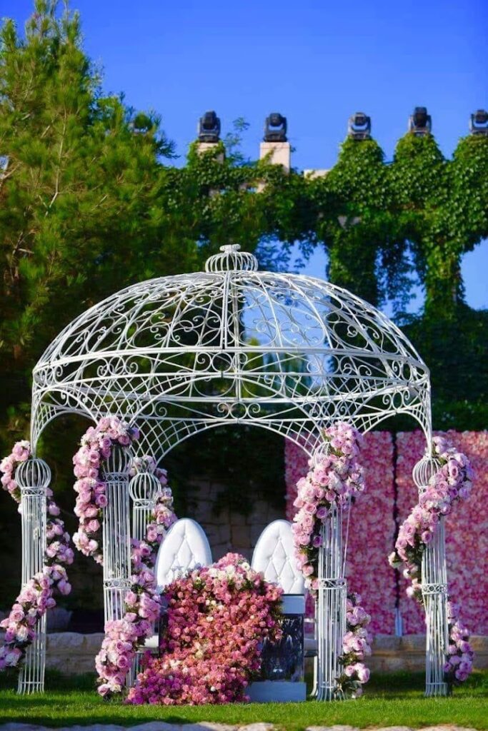 a white gazebo with pink flowers
