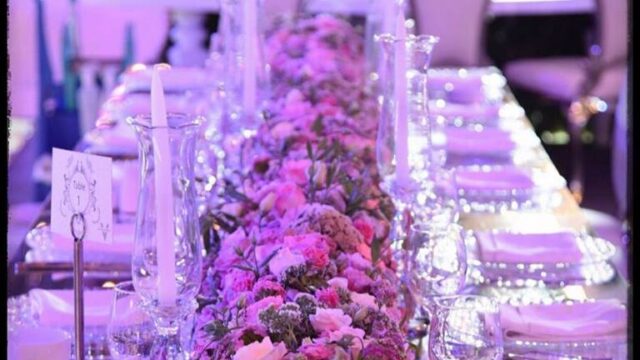 a long table with flowers and glasses