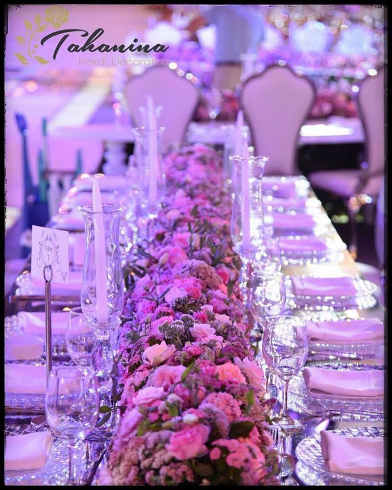 a long table with flowers and glasses