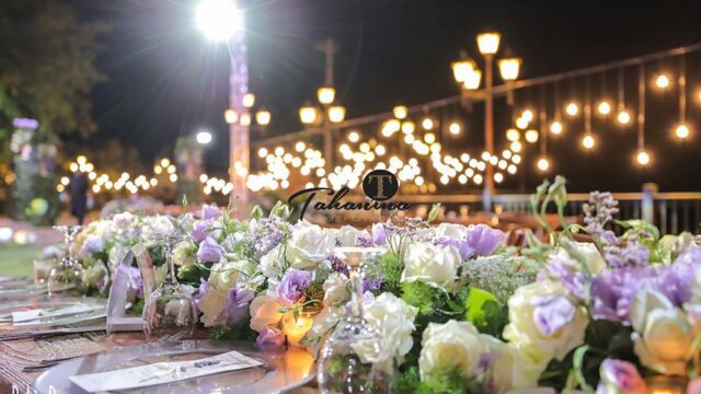 a table set with flowers and plates on it