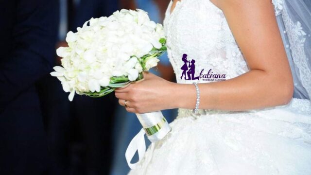 a woman in a wedding dress holding a bouquet of white flowers
