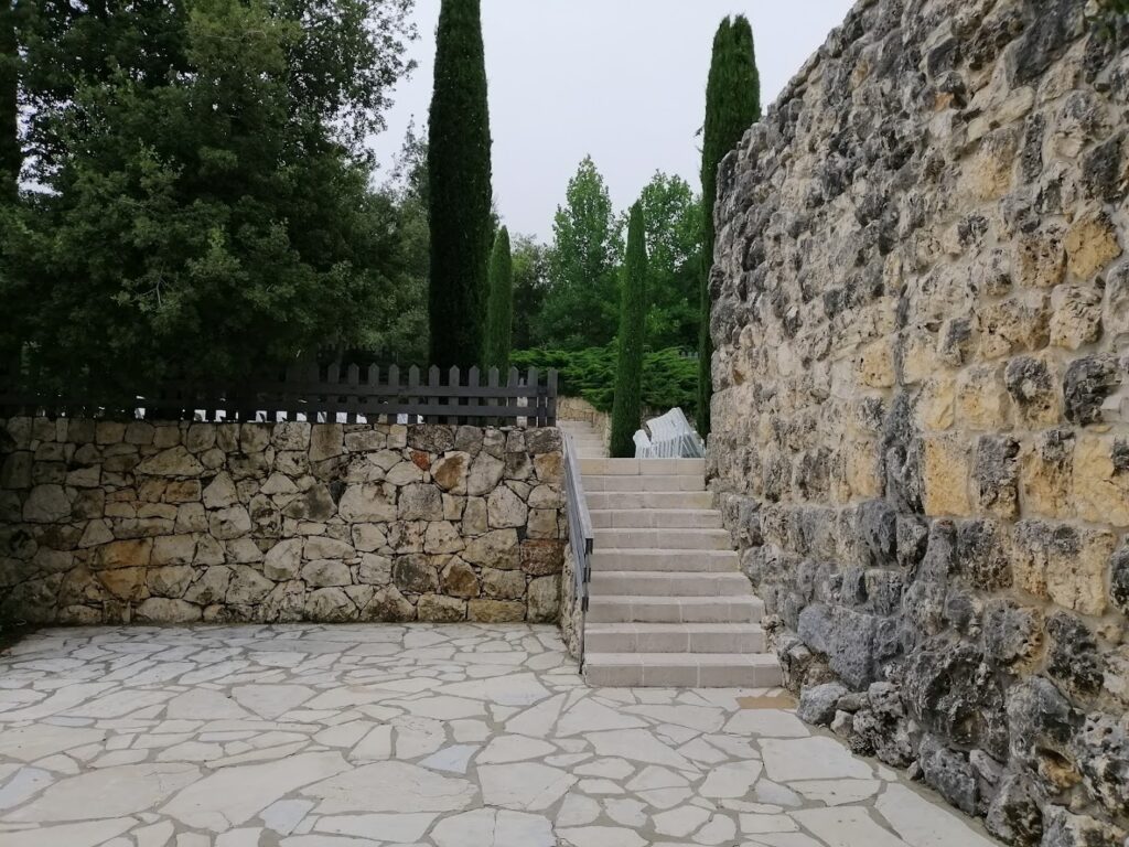 a stone wall with a stone staircase and trees