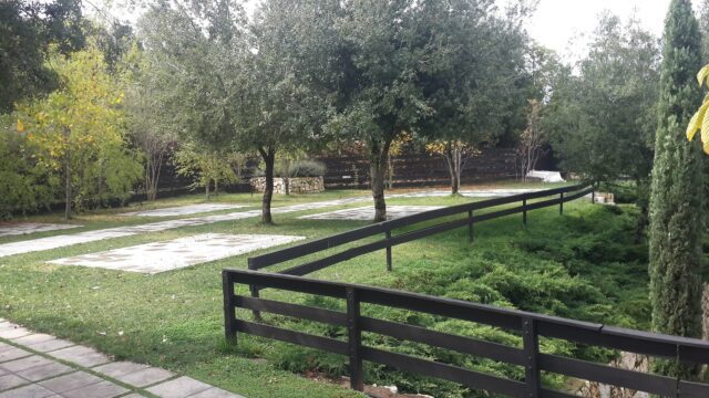 a fenced in area with trees and grass