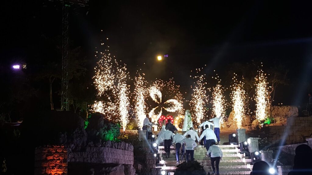 a group of people walking up stairs with fireworks in the background