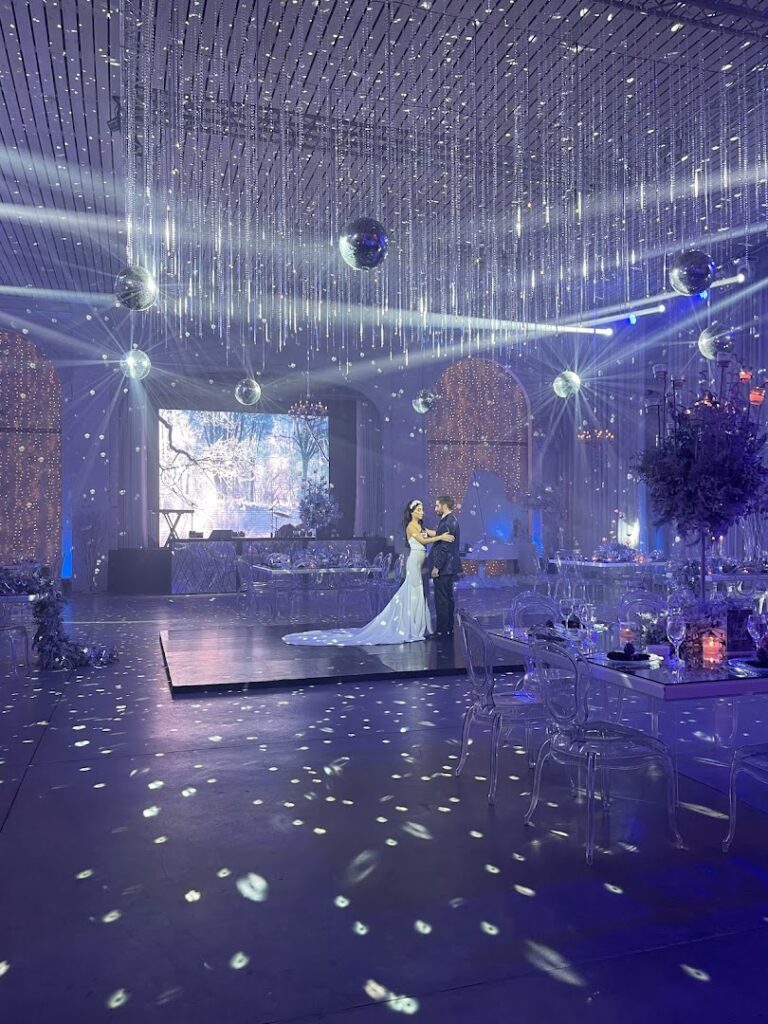 a couple dancing in a room with lights and balls