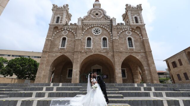 a man and woman in wedding attire standing on stairs in front of a building