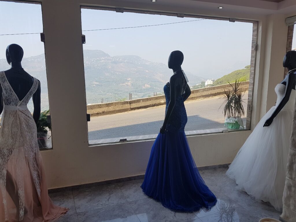 a mannequins in dresses looking out a window