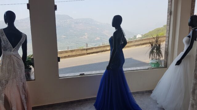 a mannequins in dresses looking out a window