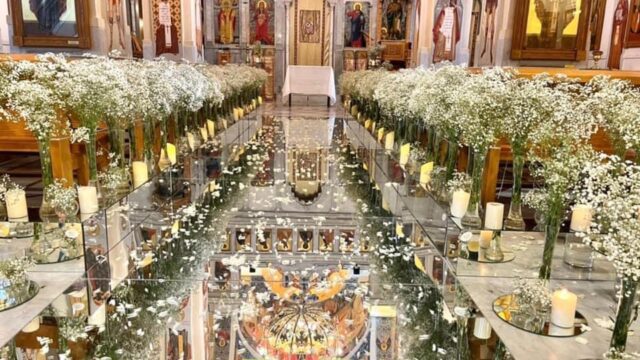 a room with white flowers and mirror tables