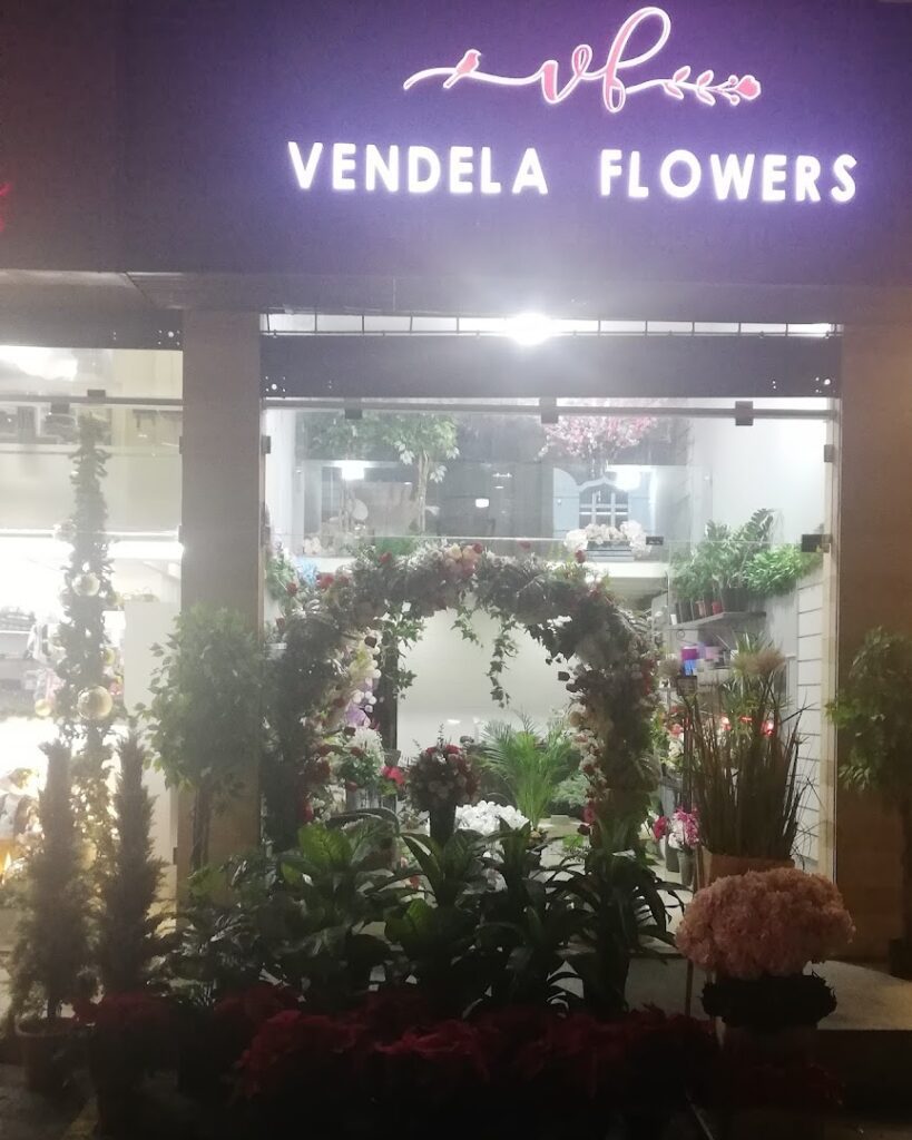 a store front with plants and flowers