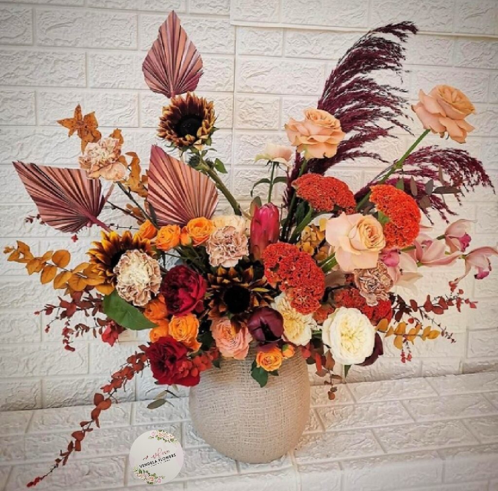 a vase of flowers on a white surface