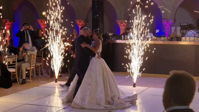 a man and woman dancing in a room with fireworks