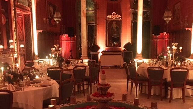 a room with tables and chairs and tables with candles and flowers