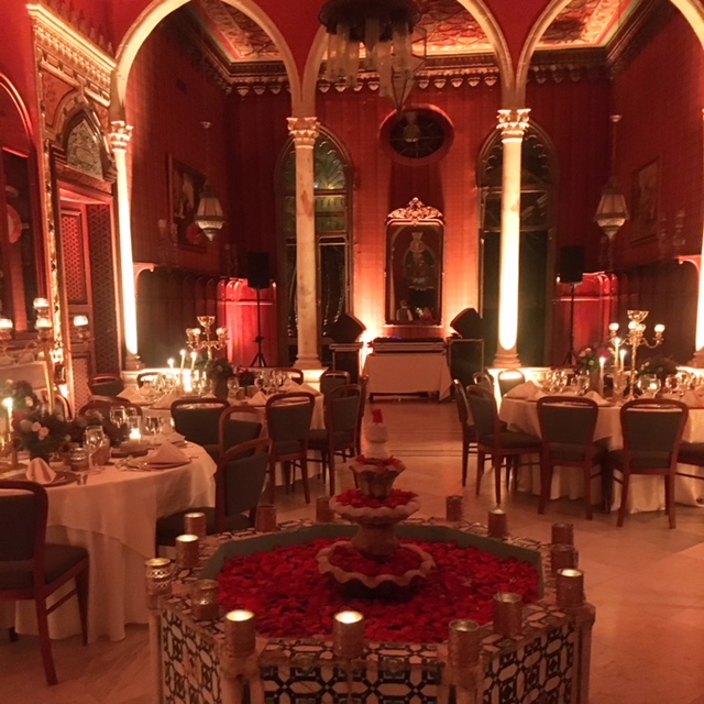 a room with tables and chairs and tables with candles and flowers