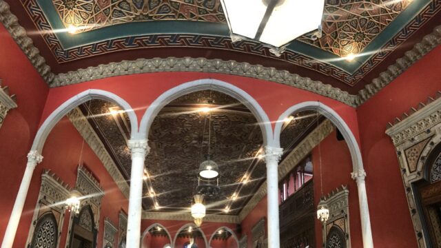 a red and white building with ornate ceiling and arches