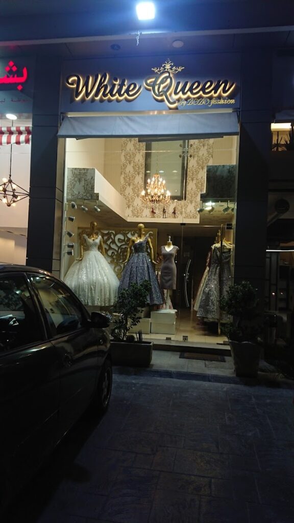 a storefront with mannequins and dresses
