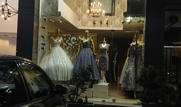 a storefront with mannequins and dresses