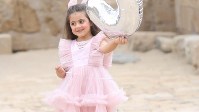 a girl holding a silver balloon