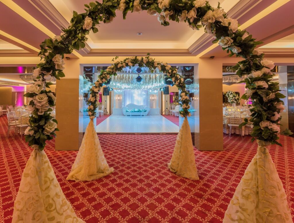 a wedding arch with flowers and a stage