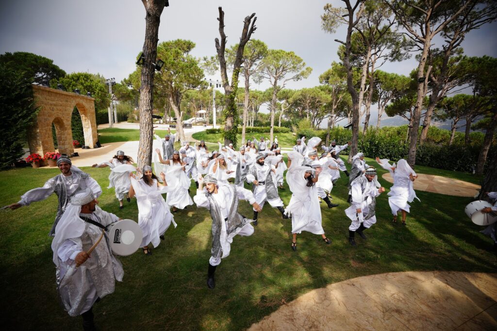 a group of people in white robes dancing in a park