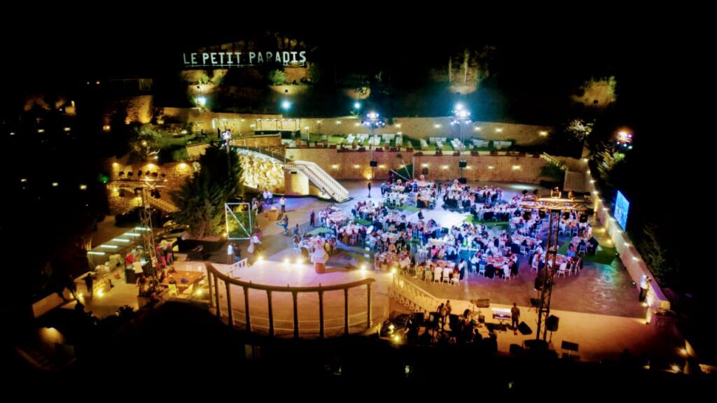 an outdoor event with people sitting around tables