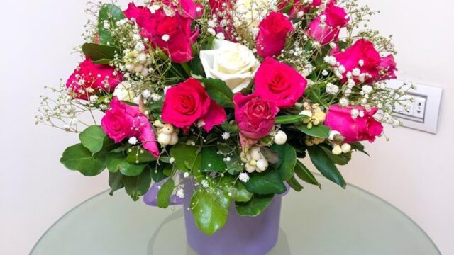 a bouquet of flowers in a purple mug on a glass table