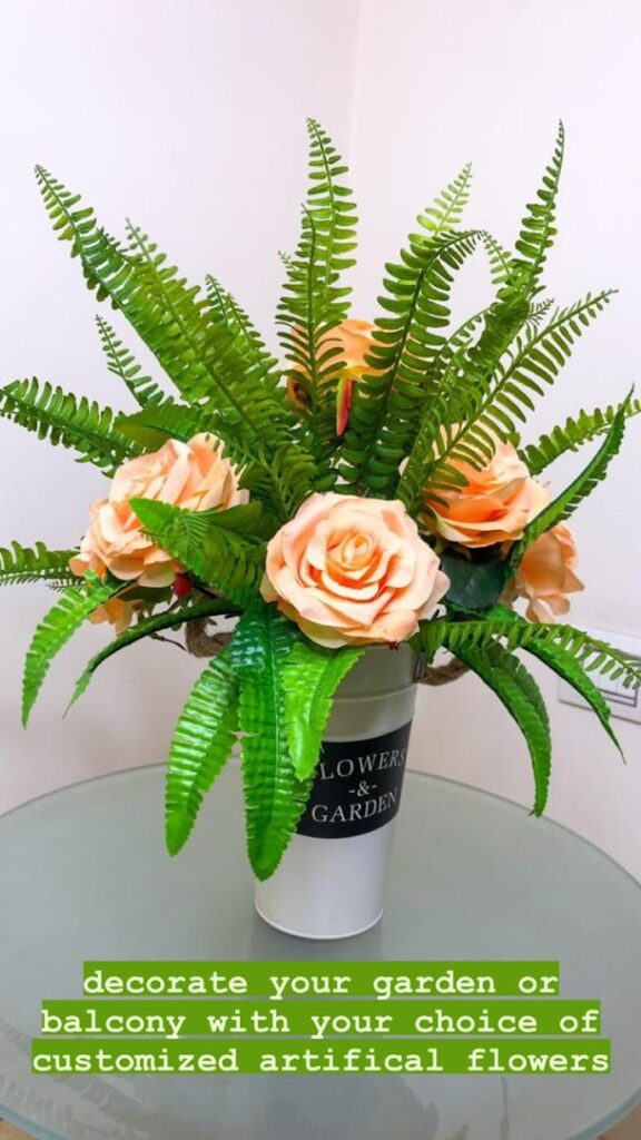 a vase with flowers and fern leaves