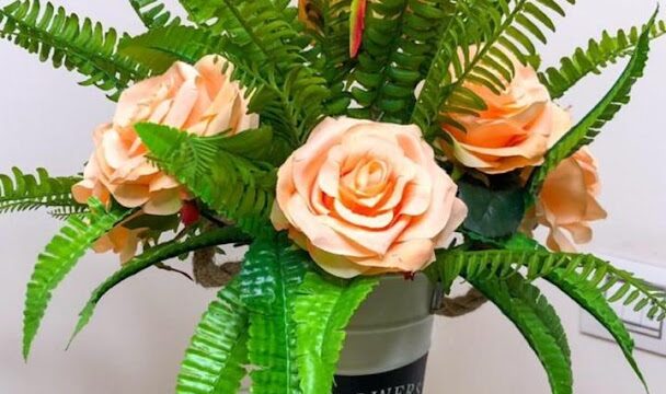 a vase with flowers and fern leaves