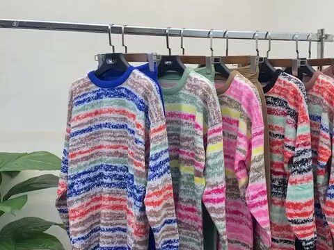 a row of sweaters on swingers