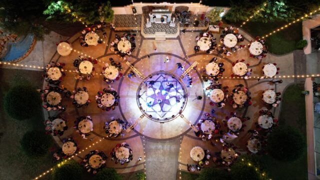 a group of people sitting at tables in a courtyard