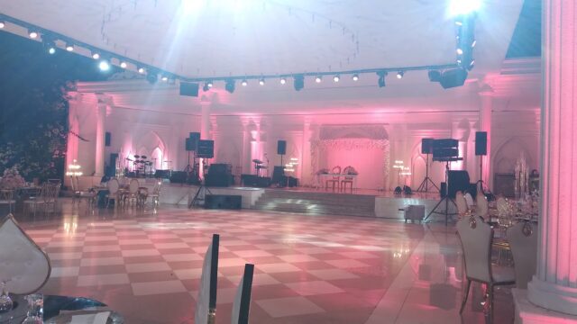 a white room with a checkered floor and a stage with lights