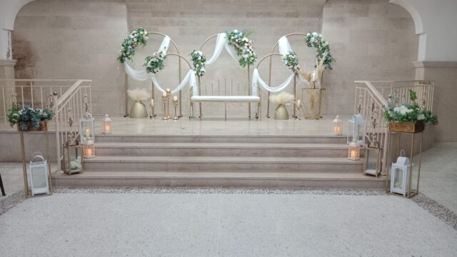 A stage with a bench and flowers, decorated by Al-Nojoom_Wedding_Center 💫since 2008 💫1st branch kabershmoun 💫2nd branch Queens plaza bouchryieh.