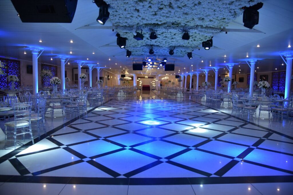 A room with white chairs and tables, Al Tawahin (Kalaa Weddings).