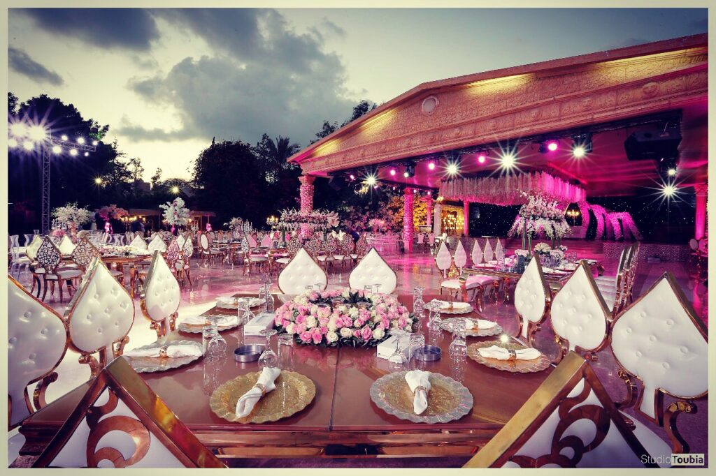 A large outdoor event with tables and chairs, featuring Al Tawahin (Kalaa Weddings).