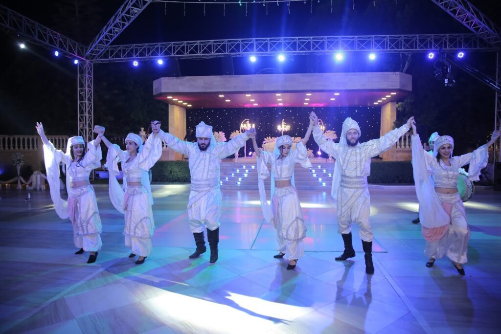 a group of people in white clothing on a stage