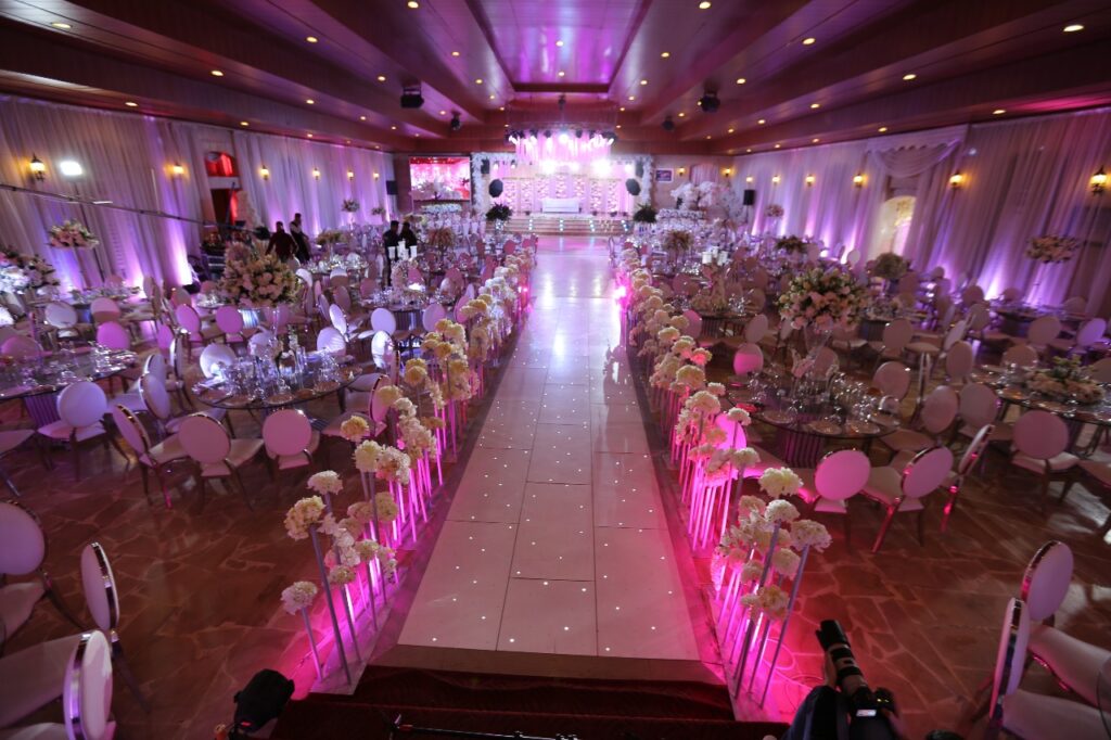 a room with tables and chairs and pink lights