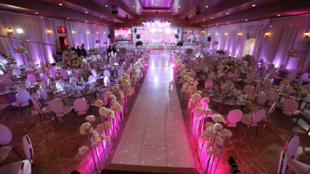 a room with tables and chairs and pink lights