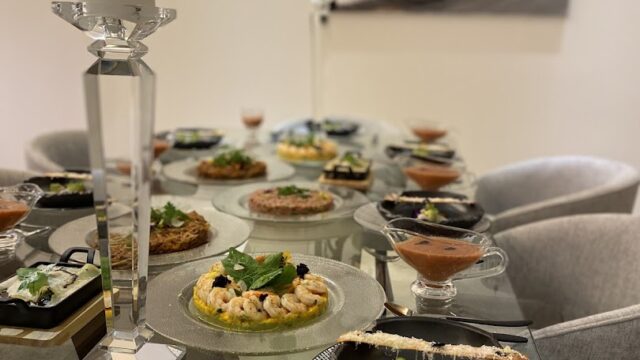 Aleen catering set up a table with plates of food and a candle.