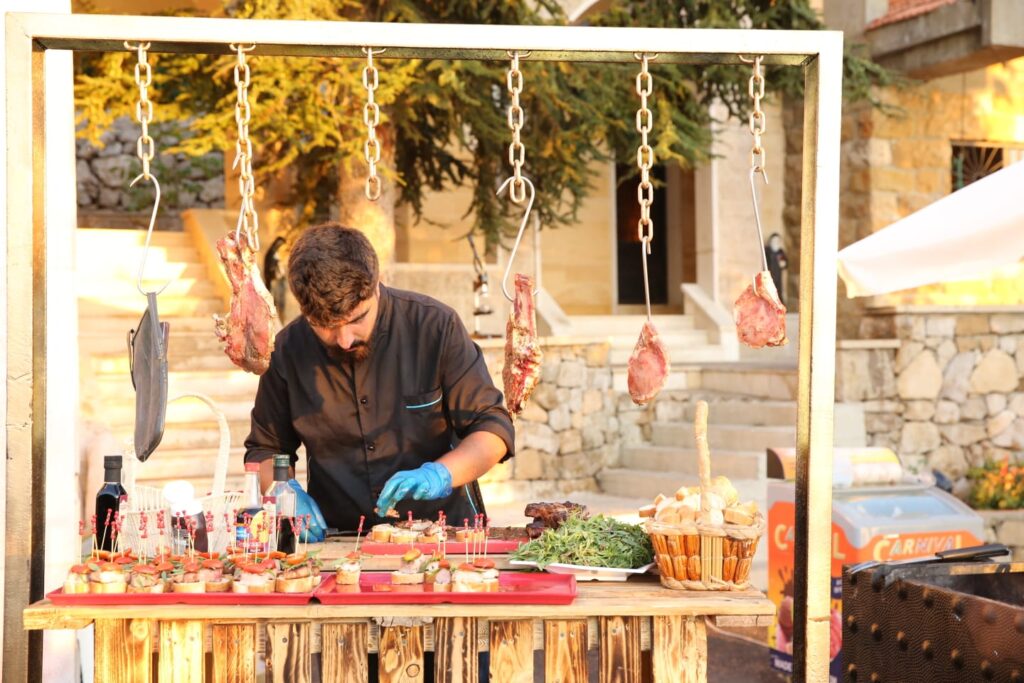 "A man standing at a food stand, representing Baskinta Catering."