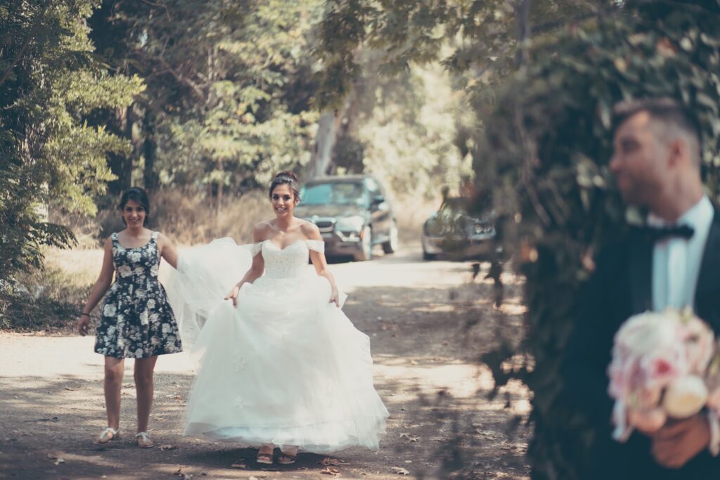 a woman in a dress walking down a path with a woman in a dress