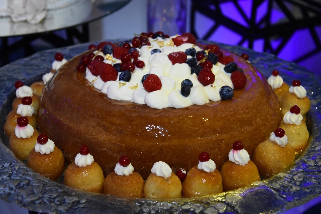 Bluemz Catering presents a delectable cake with berries on top.
